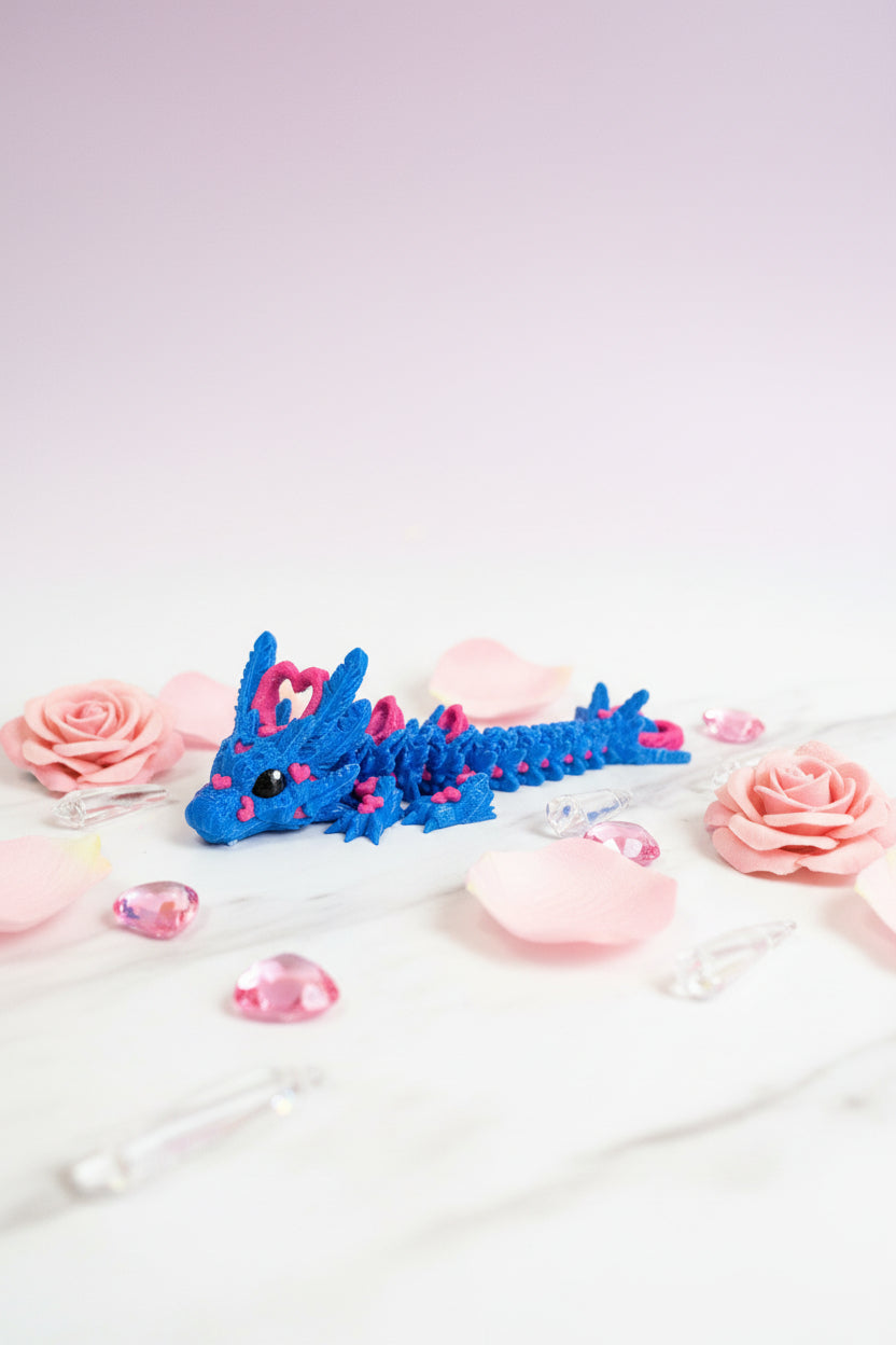 Plüschtier-Babydrache in Blau mit pinken Herzapplikationen und seitlicher Ansicht
