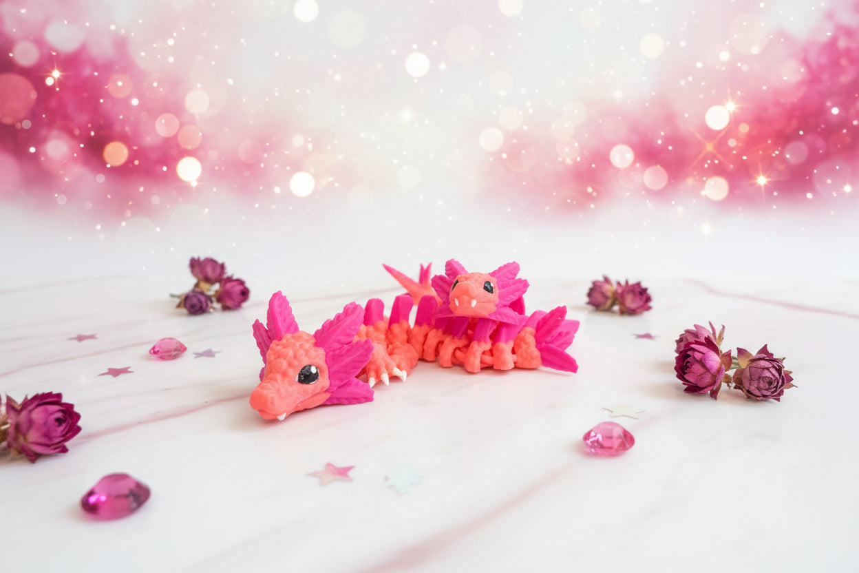 3D-Axolotl-Drache in Orange und Pink, zwei kleine Exemplare eng beieinander