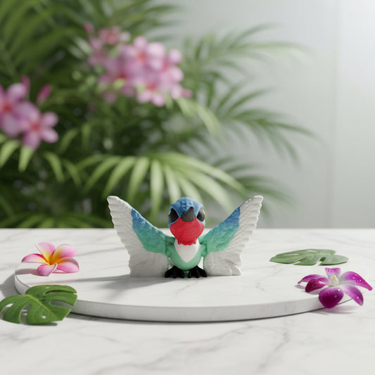 Kleines Kolibri-Spielzeug in Blau mit weißen Flügeln, roter Brust und schwarzem Schnabel