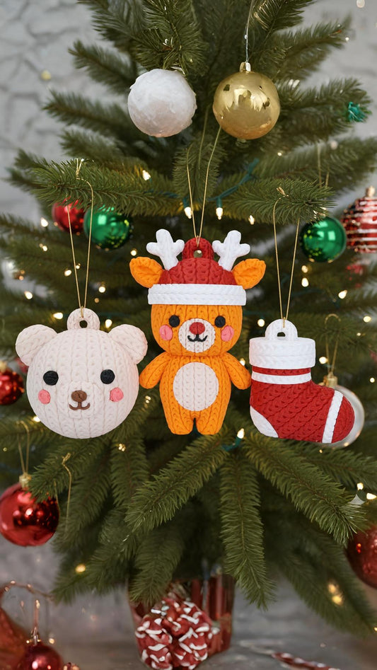 Gestrickter Weihnachtsanhänger mit Bär, Rentier im Hut und Weihnachtssocke am Tannenbaum
