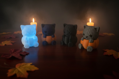Gestrickte Katzenfiguren im Kürbis-Design, blau, dunkelgrau und weiß, orangefarbene Kürbisse