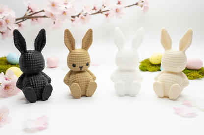 Strickhasen-Figuren in Schwarz, Beige und Weiß auf einer Osterausstellung