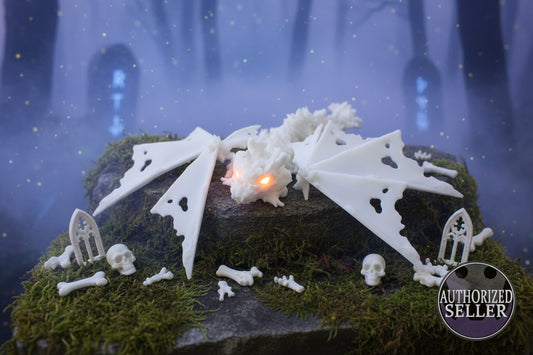 Weiße Drachenknochenfigur mit zwei Flügeln und kleinem Skelett, leuchtende Spitze
